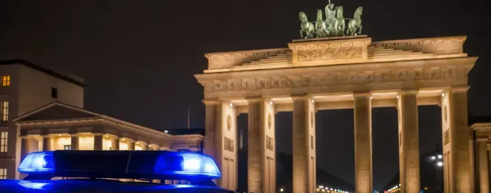 Berlin bei Nacht mit Polizeipräsenz und Blaulicht nahe dem Brandenburger Tor – Symbolbild